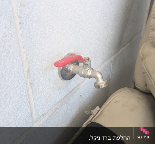 ברז מים מותקן על קיר לבן